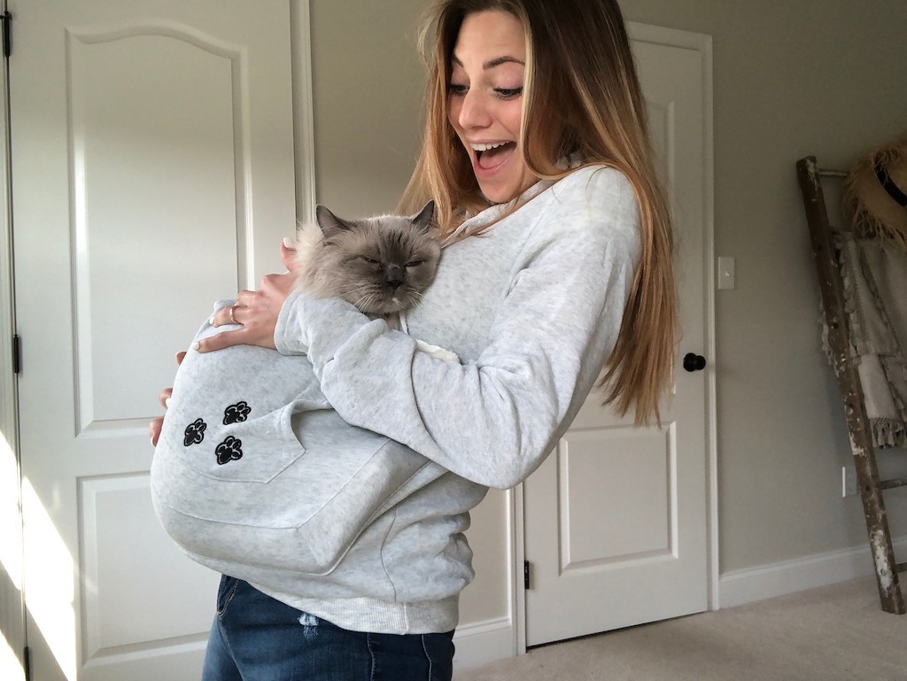 woman wearing hoodie with cat inside pouch