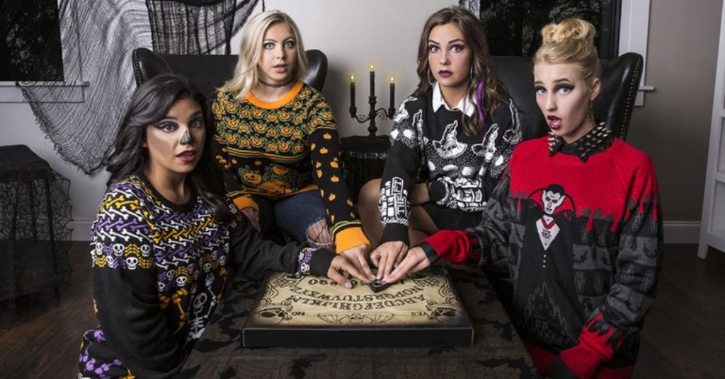 4 women wearing ugly Halloween sweaters