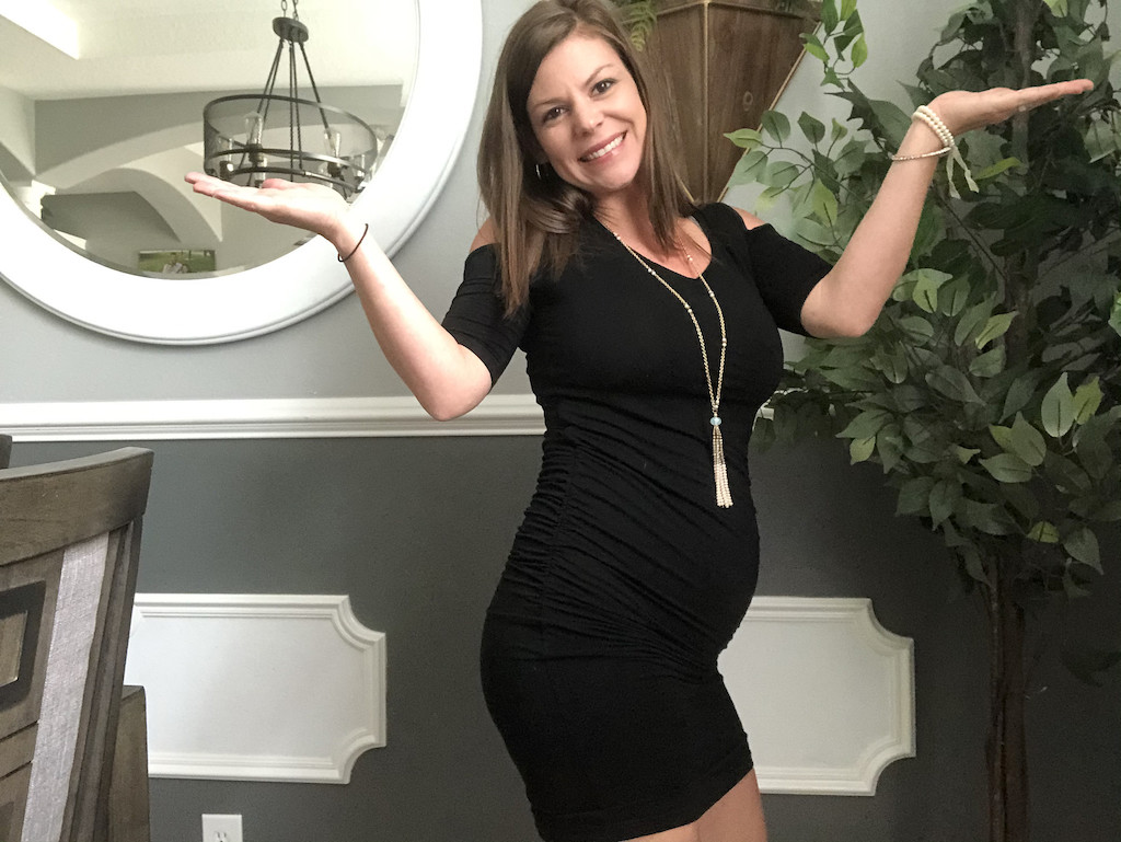 woman smiling wearing black maternity dress 