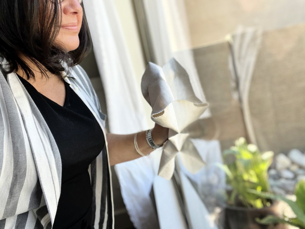 woman washing a window with microfiber car cloth