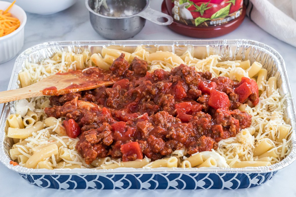 preparing baked ziti noodles and meat sauce