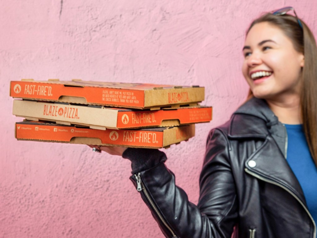 Girl holding blaze pizza boxes