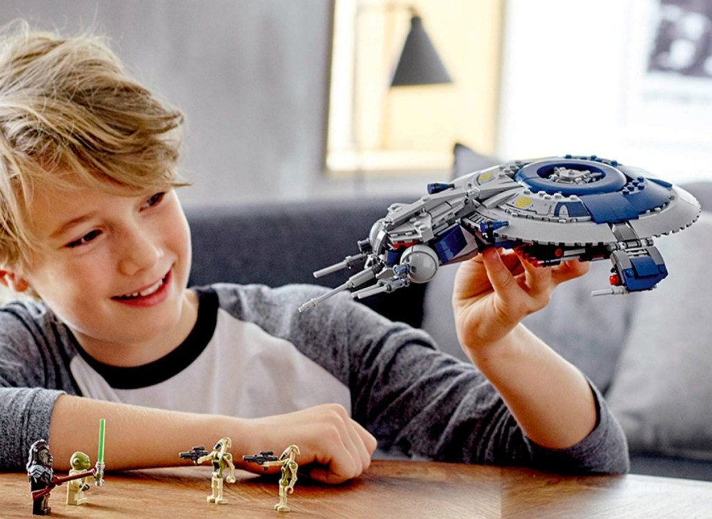 boy playing with LEGO Star Wars set