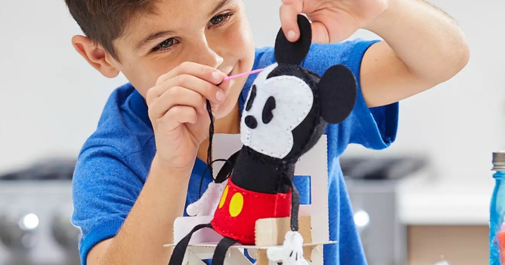 Boy playing with a plush Mickey Mouse