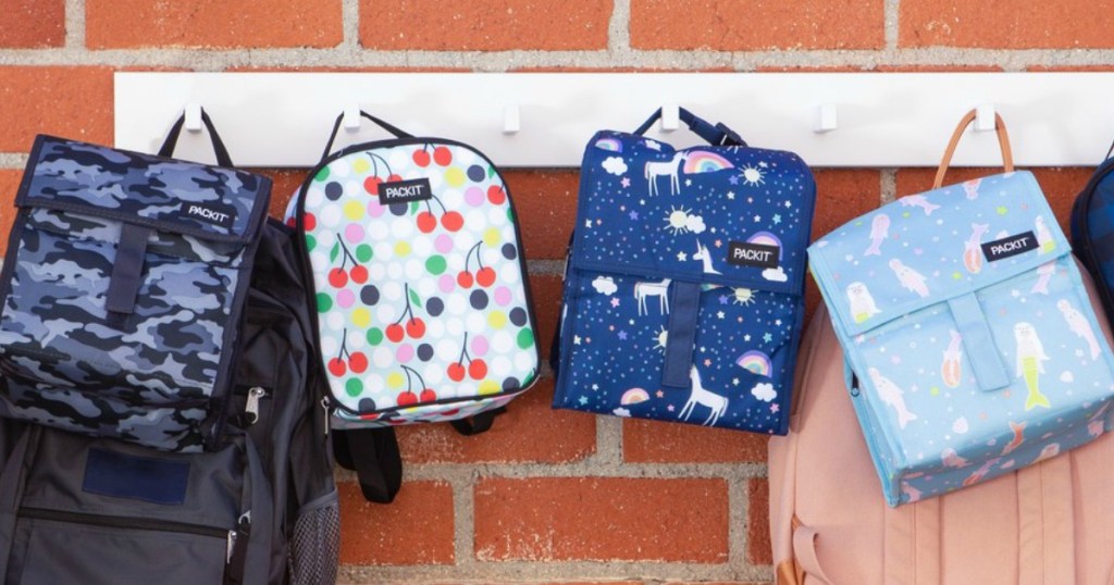 Four styles of freezable lunch bags hung on school wall