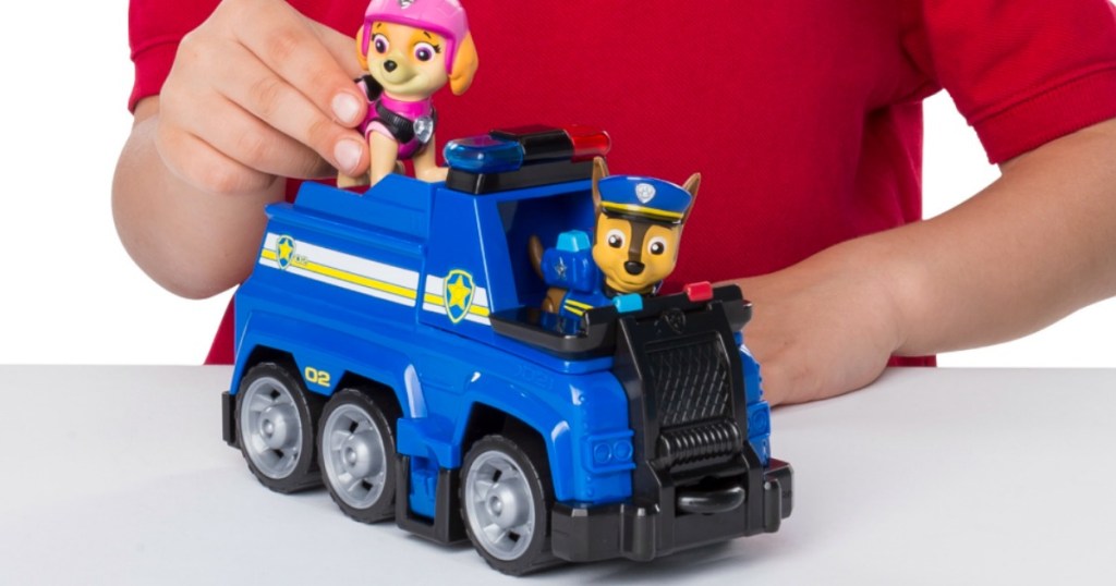 Boy playing with Paw Patrol playset police vehicle and two characters