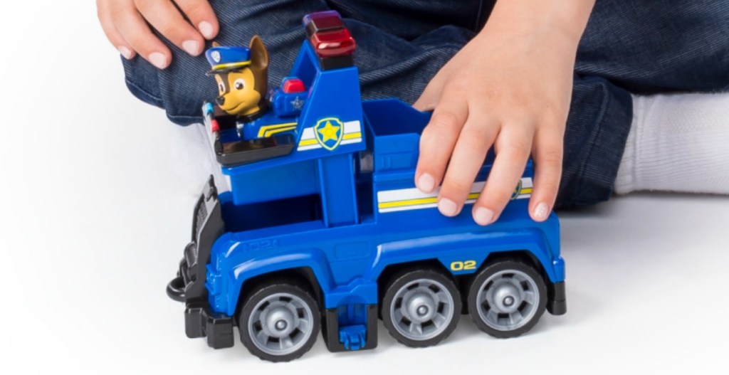 Boy playing with Paw Patrol vehicle playset - police car