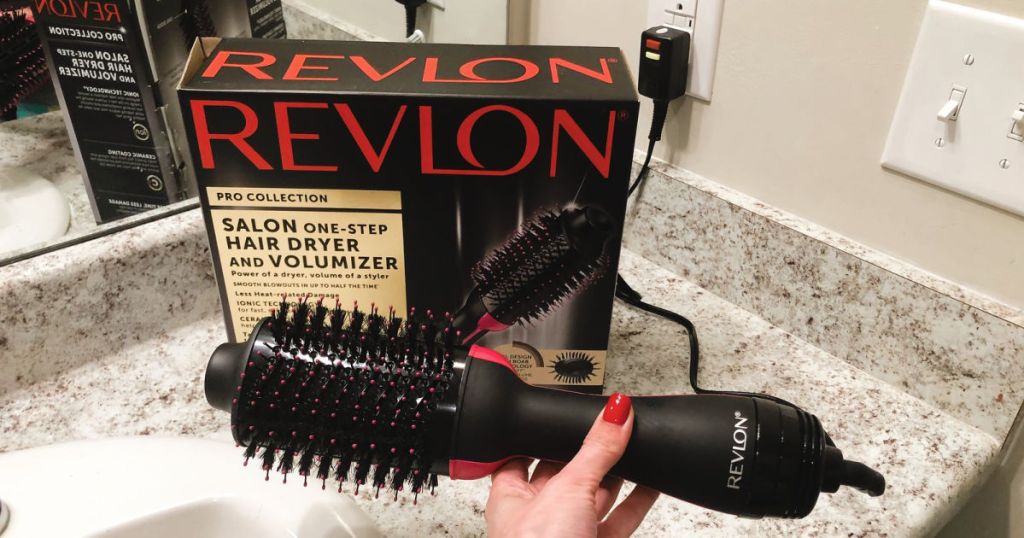 hand holding Revlon Hair Dryer And Volumizer box and dryer on countertop in bathroom