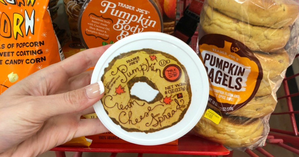 women's hand holding Trader Joe's pumpkin cream cheese spread in store