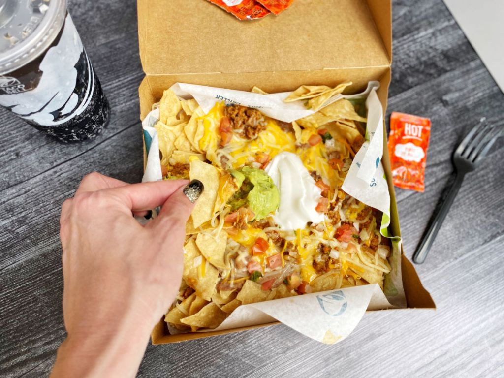 Taco Bell Nacho Box dipping in guacamole