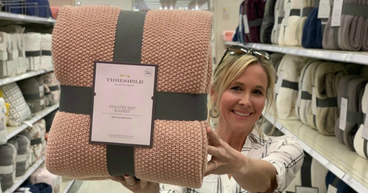 woman holding pink blanket inside store