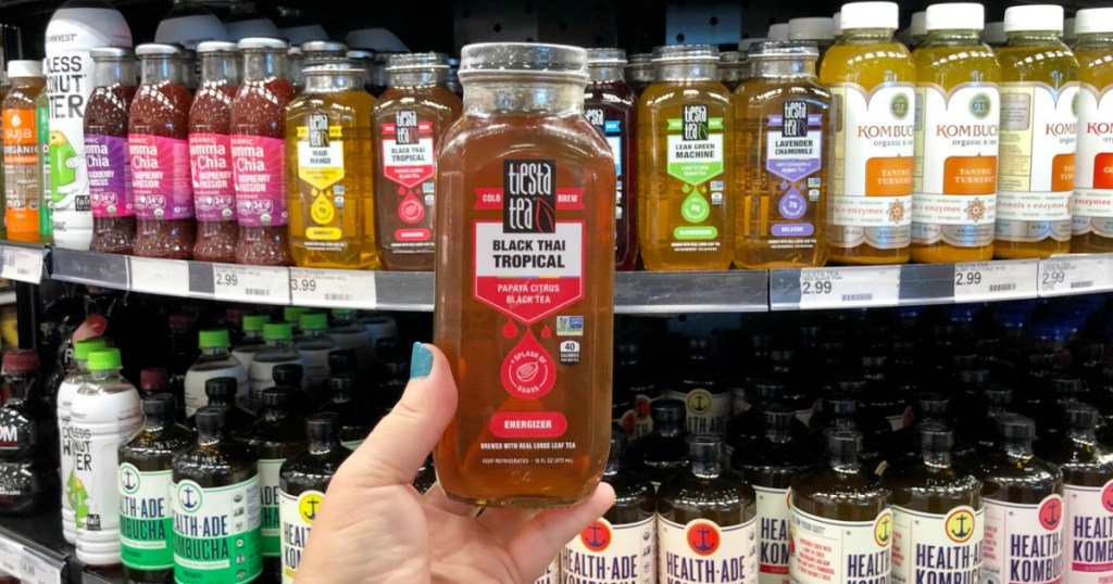 woman holding up a bottle of Tiesta tea in-store