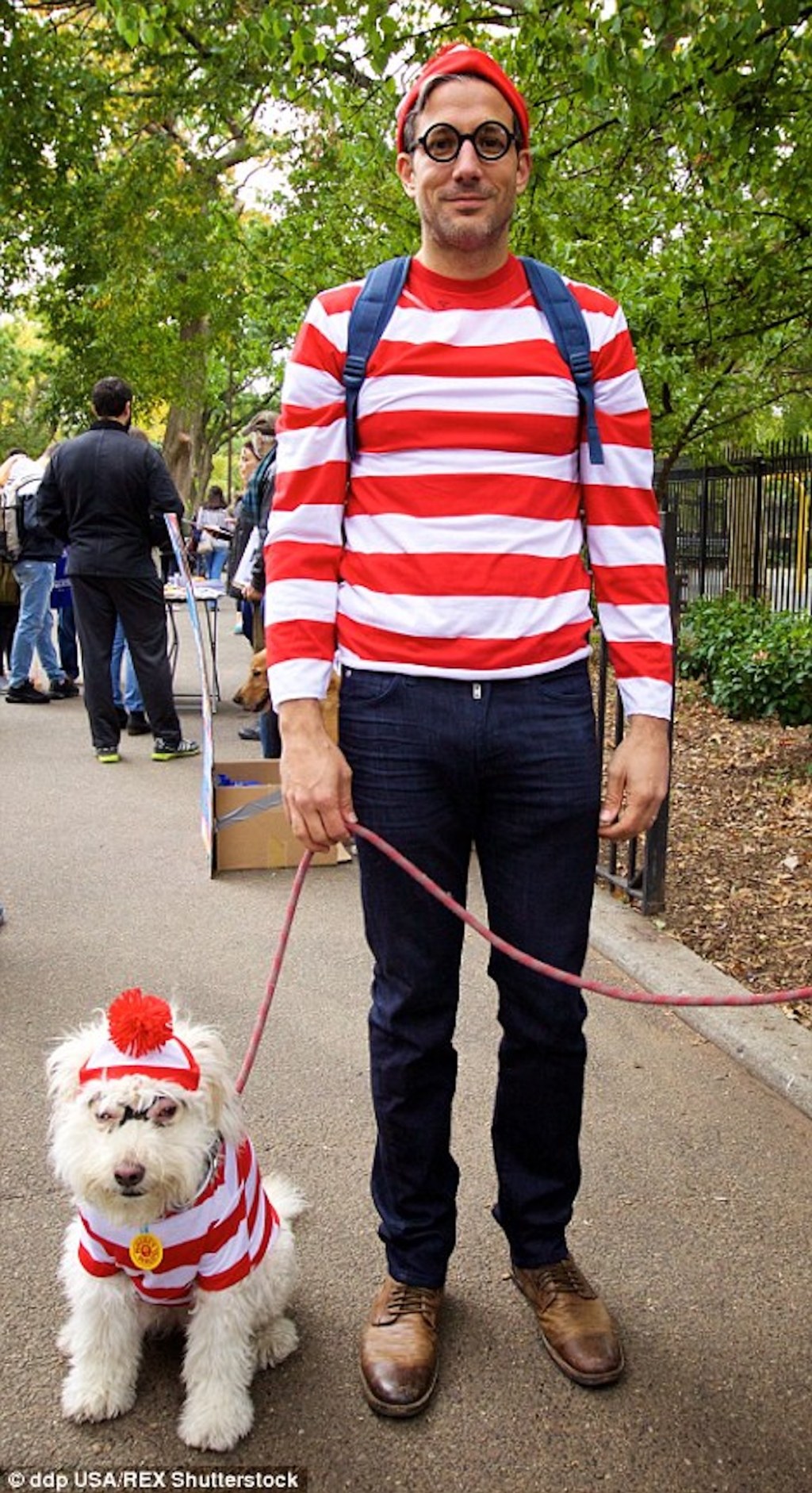 man and dog dressed up as where's waldo outside