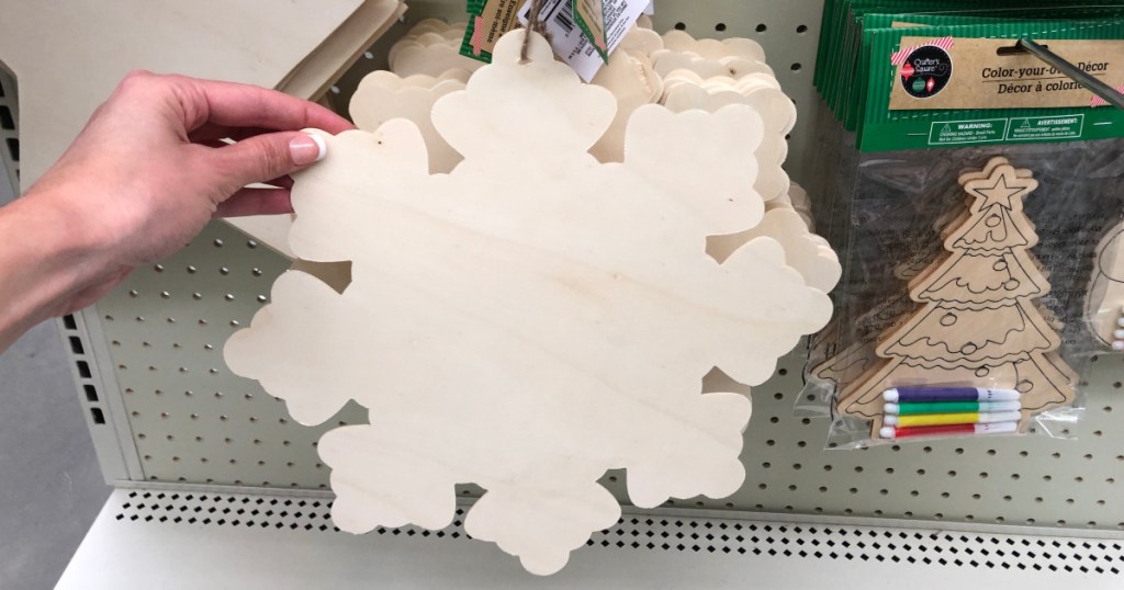 hand holding up wooden snowflake