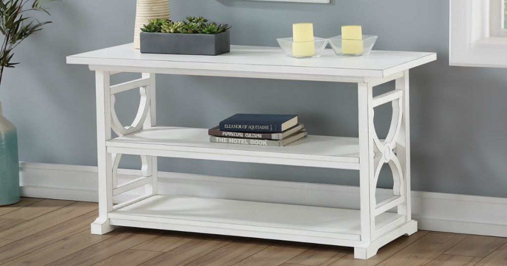 white accent table with candles and books on it