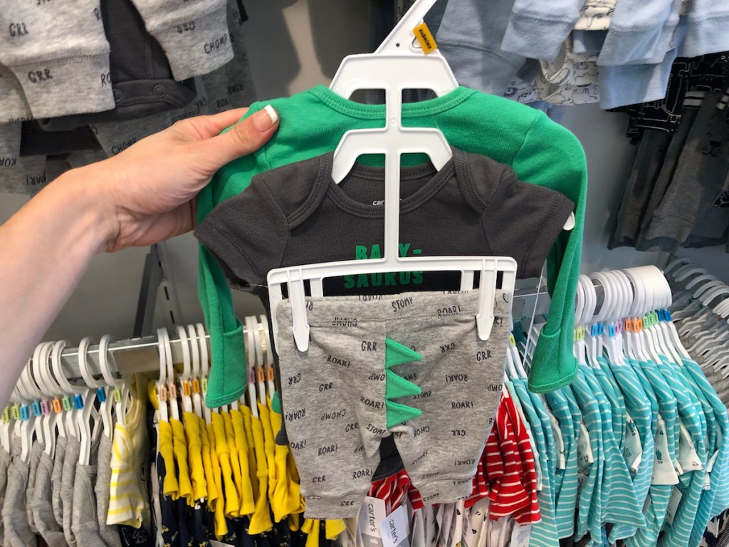 carter's 3-piece set held up in front of store rack