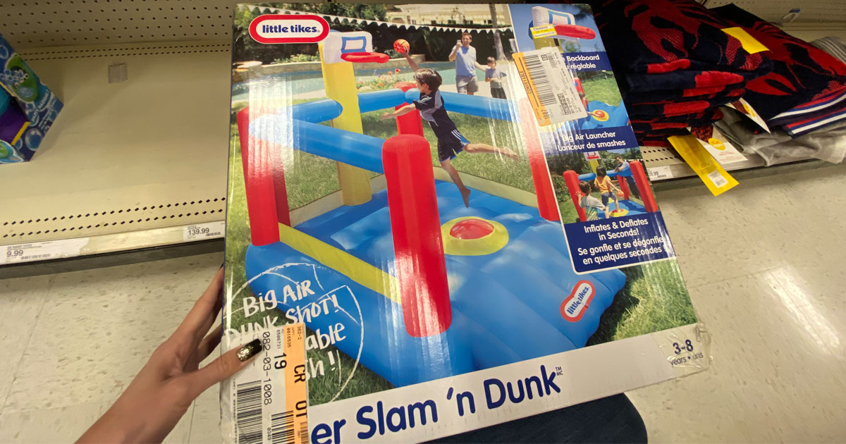 in store picture with hand holding a little tikes slam n dunk bounce house