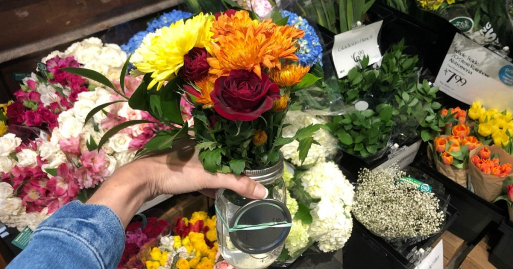 hand holding mason jar full of flowers