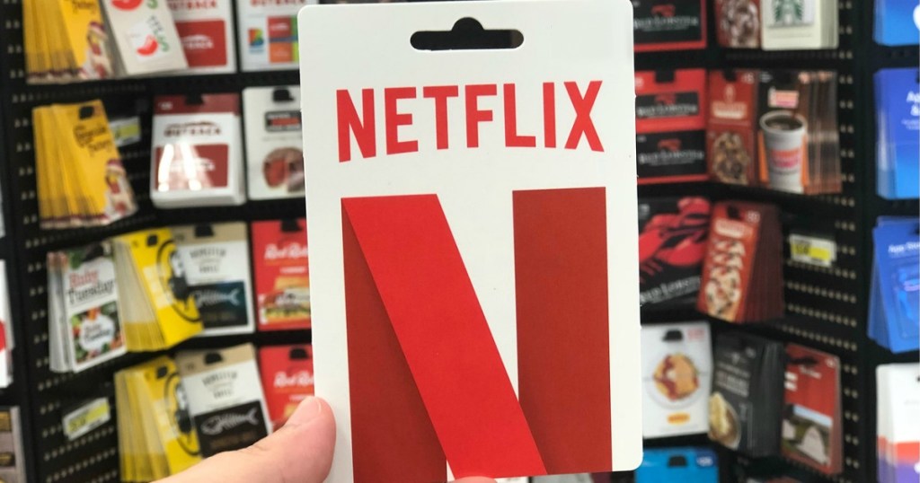 hand holding netflix gift card by store display