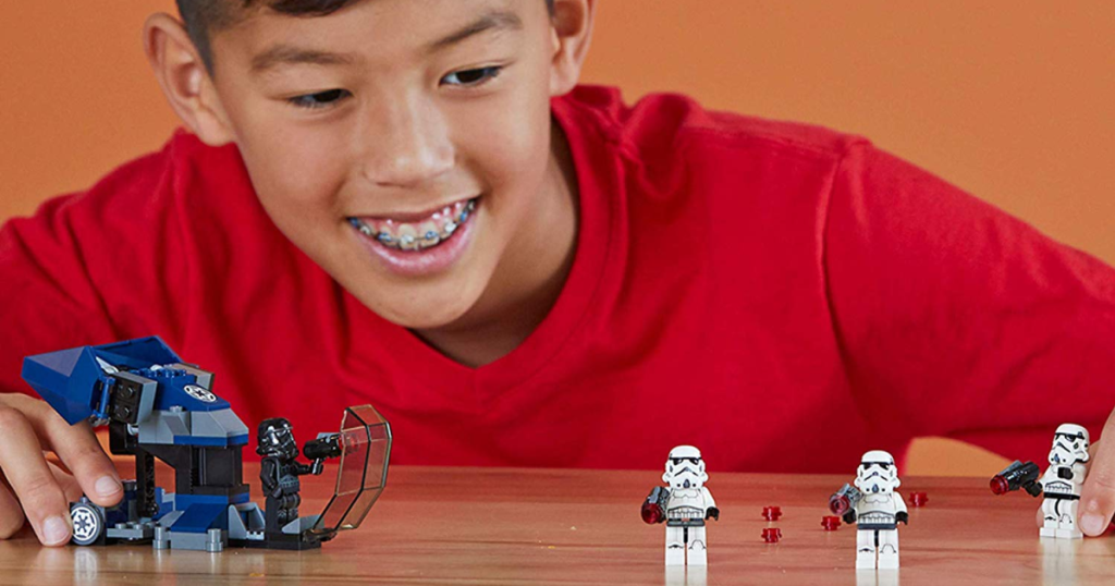 kid in red shirt playing with lego toys