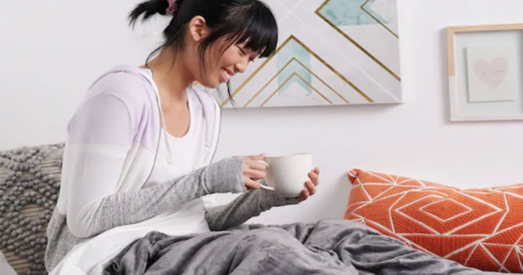 girl laughing drinking tea wrapped in weighted blanket