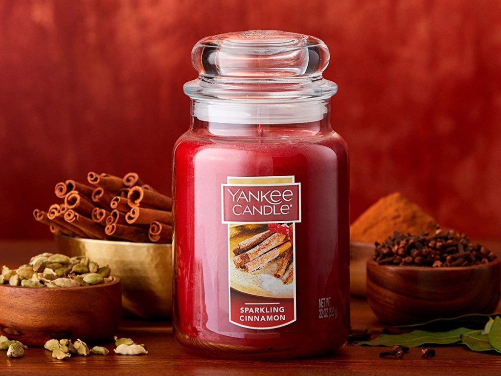 yankee candle sparkling cinnamon candle with cinnamon in bowls behind it