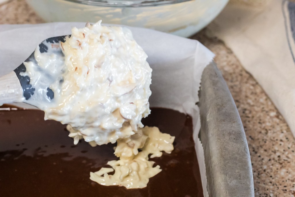 adding creamy coconut filling to brownies