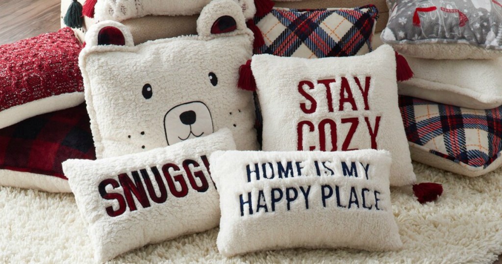 Cuddl Duds Holiday Throw Pillows stacked on carpeted floor