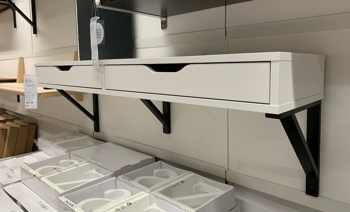 white drawers shelf on wall with black brackets 