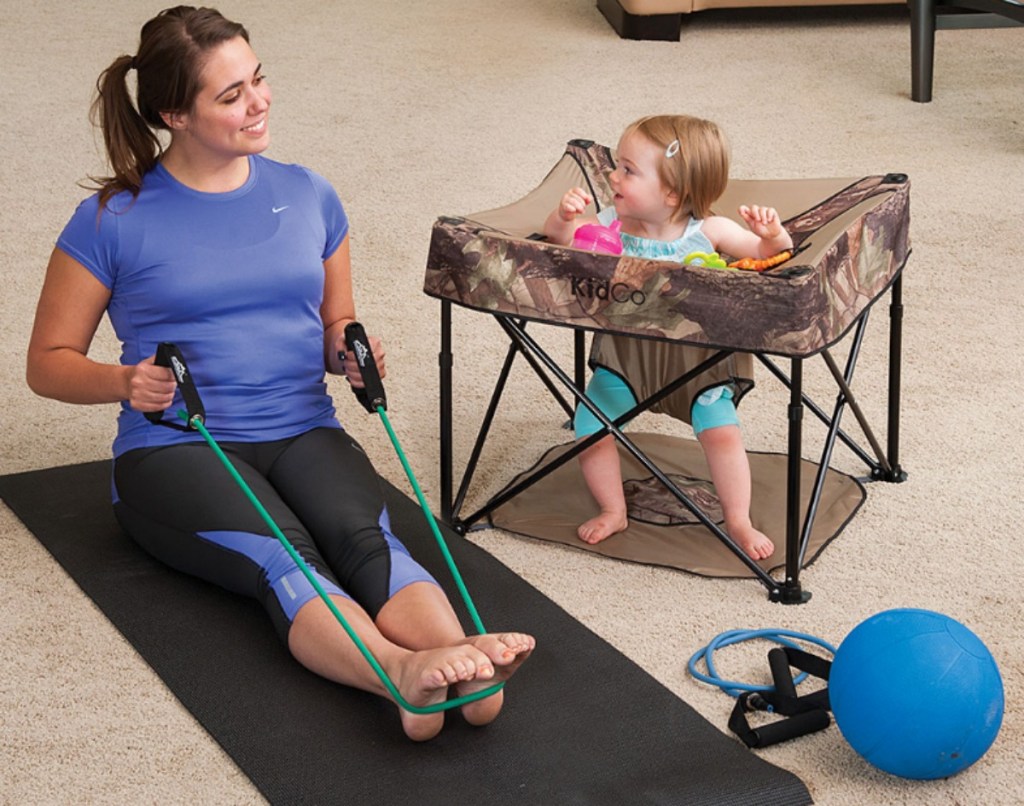 woman stretching on a yoga mat near a toddler girsl in a GoPod activity center