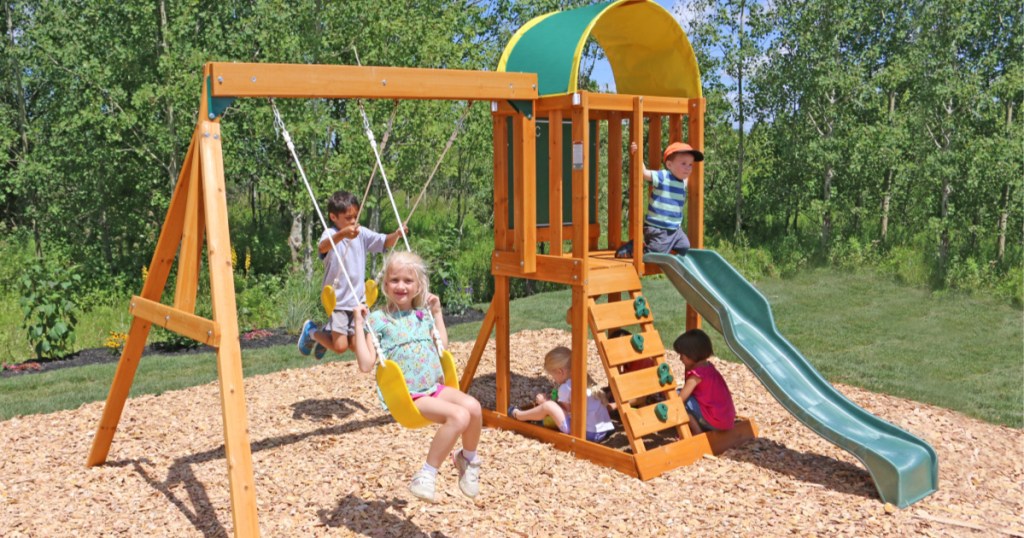 kids playing on kidkraft wooden swingset