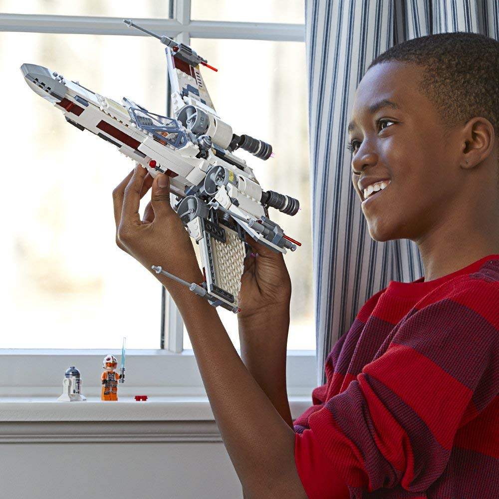 boy playing with LEGO X-wing