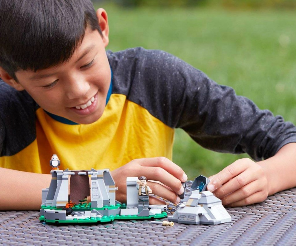 boy playing with a LEGO star wars set outside