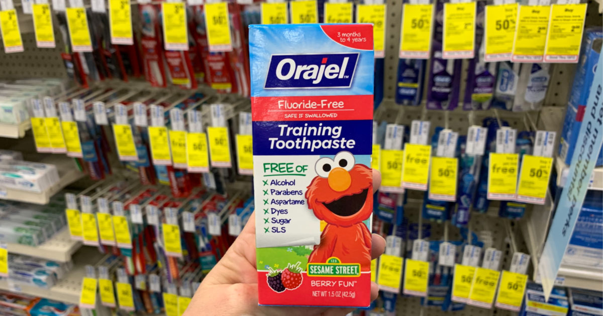 Hand holding Orajel toothpaste