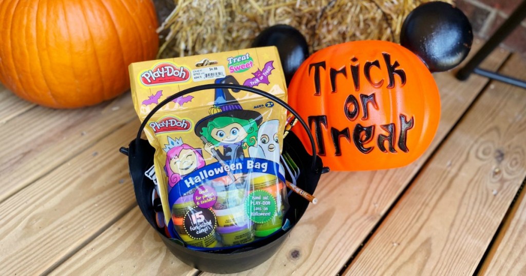 Play-Doh Halloween bag in trick or treat bucket next to Halloween decor on porch