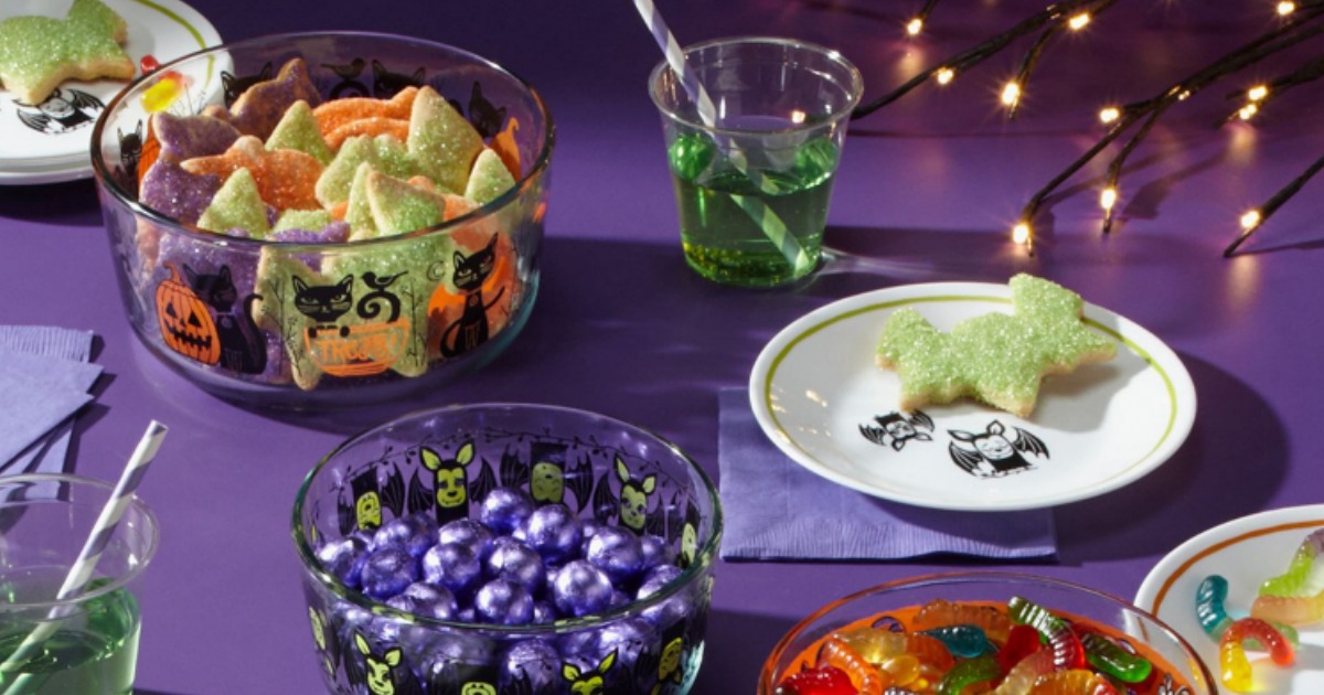 Pyrex Halloween containers on table with purple tablecloth and other Halloween decor