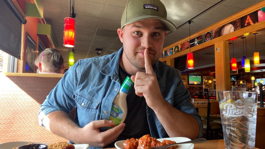 man sitting in restaurant with ranch dressing in his shirt