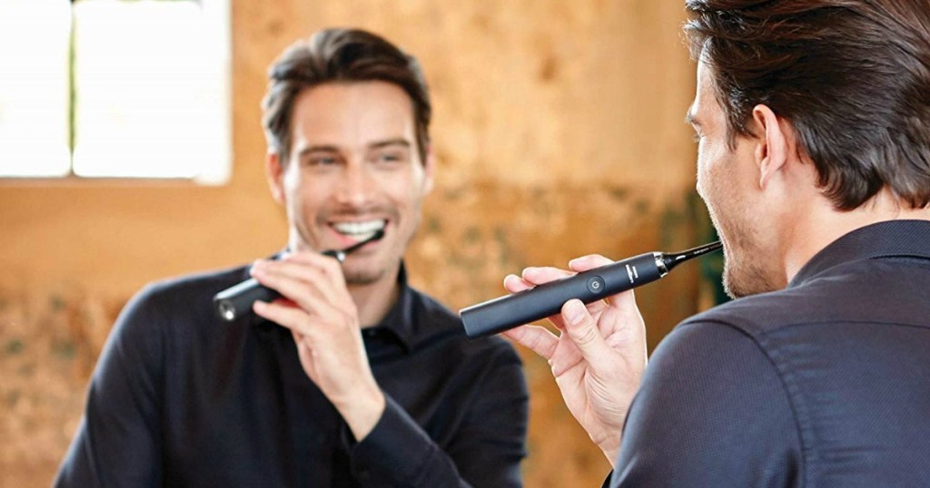 man brushing with black Sonicare DiamondClean Toothbrush in bathroom