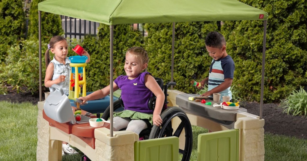 kids playing with step2 patio playhouse