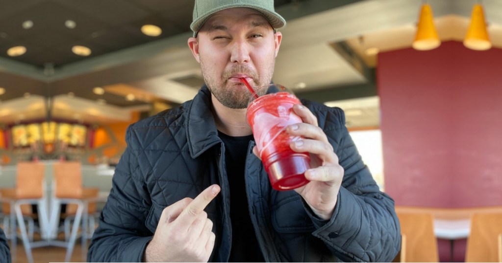 Man drinking Sour Strawberry Skittles Freeze at Taco Bell