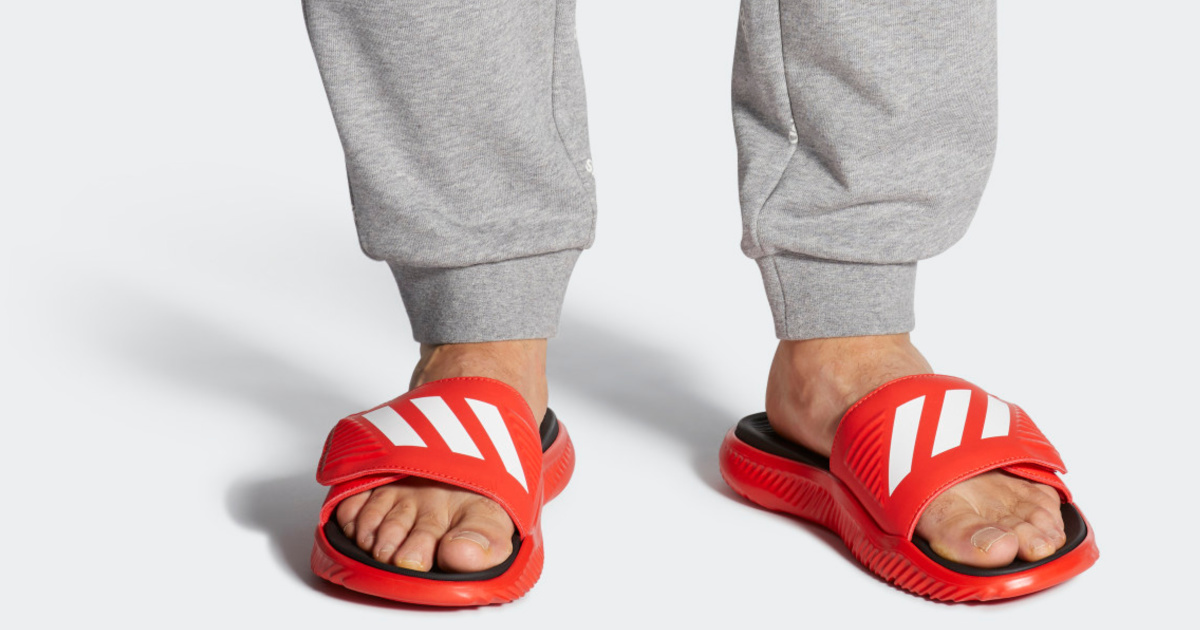 man wearing adidas slides