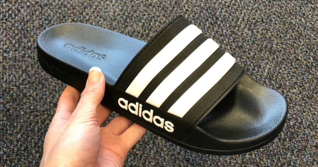 hand holding up adidas Slides