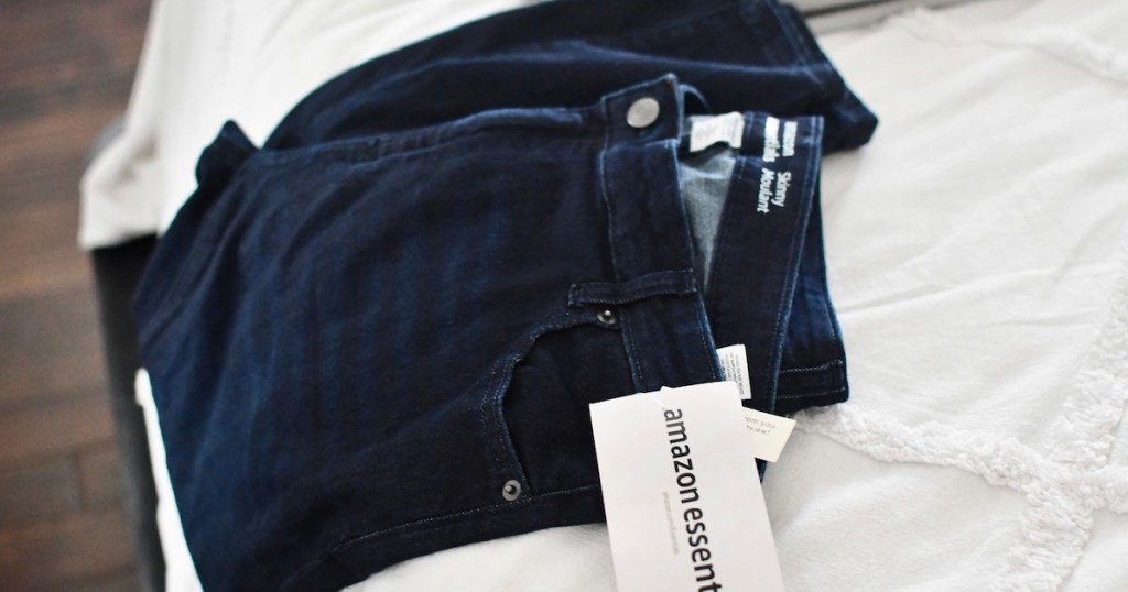 dark wash jeans laying on bed with amazon essentials tag