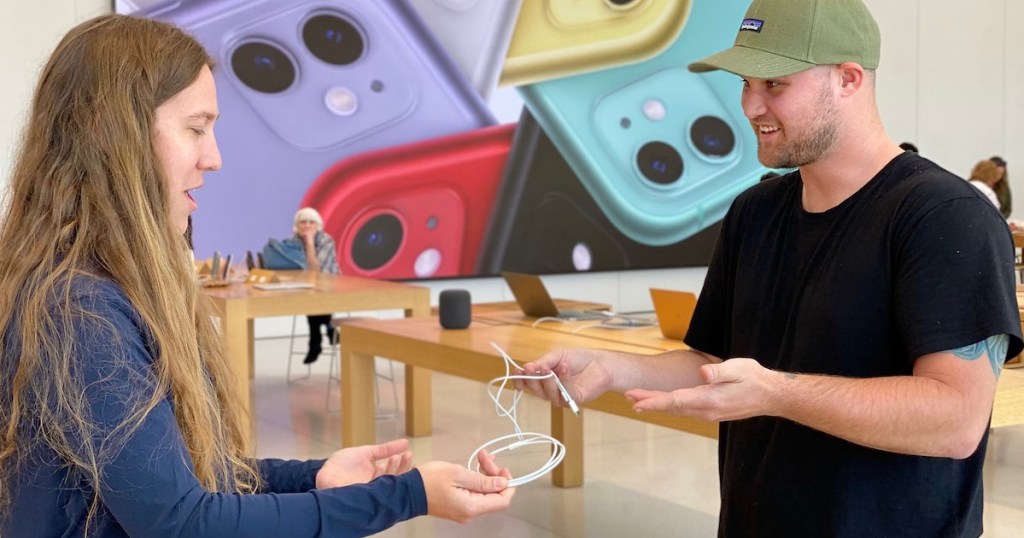 man and apple store employee exchanging phone chargers 