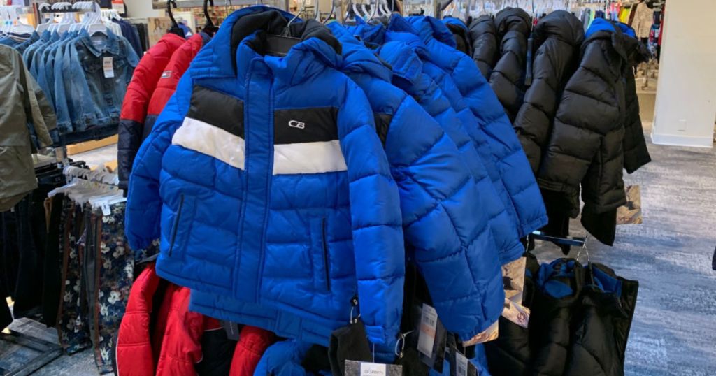 blue and white and black puffer jacket hanging in store