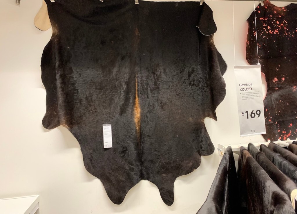 black brown cowhide rug hanging from wall