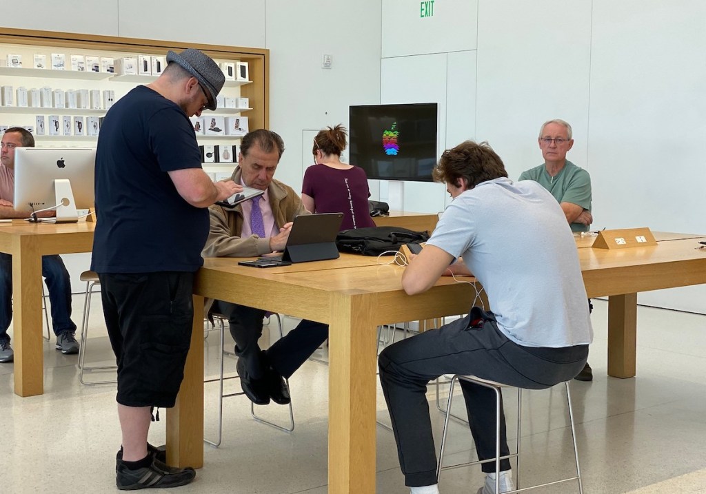 people standing at genius bar at apple store