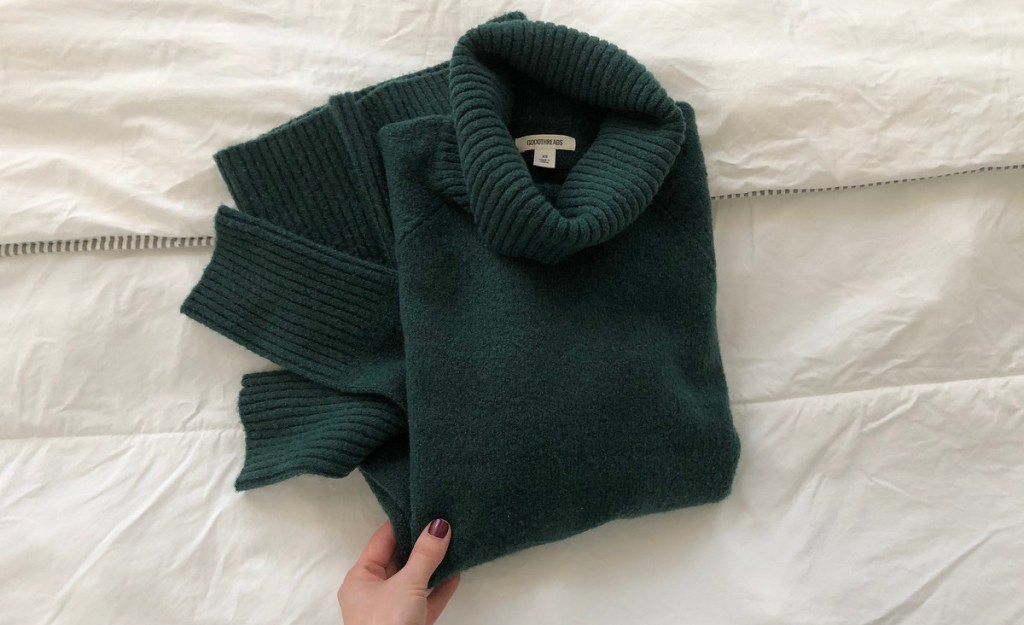 hand holding emerald green sweater