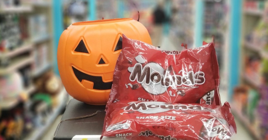 plastic pumpkin with bags of halloween candy