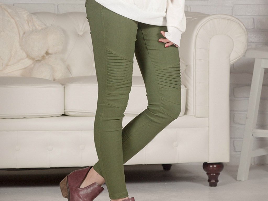 woman's legs with green pants in front of couch